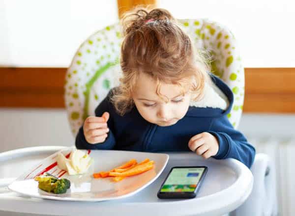 Vừa ăn vừa xem điện thoại là một thói quen không tốt cho trẻ nhỏ